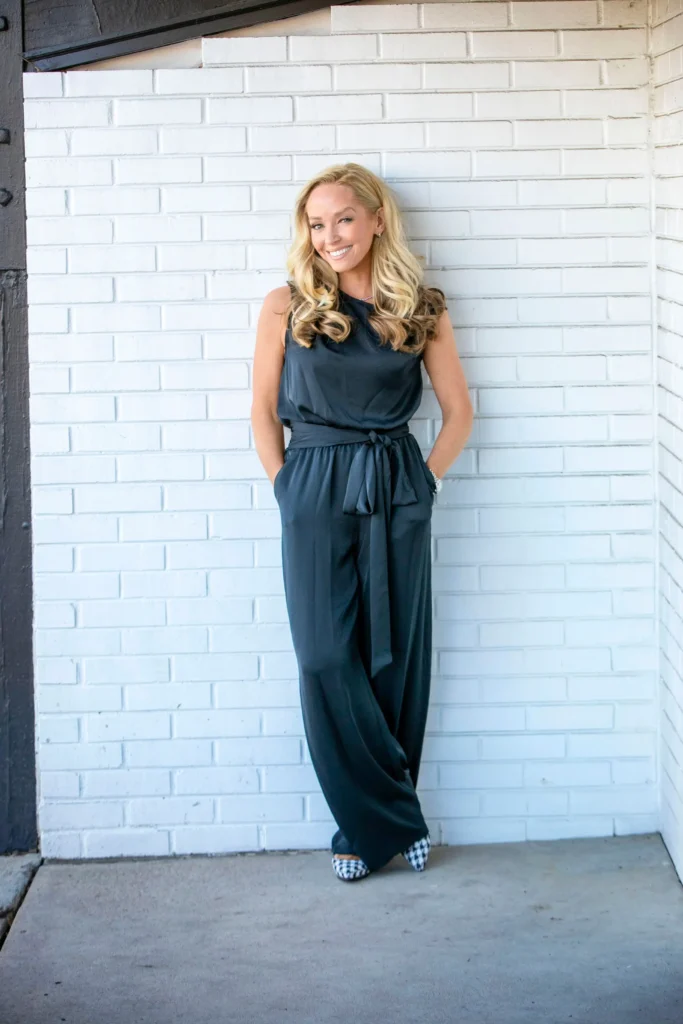 Denver Realtor Lindsay Lewis standing in front of a white brick wall